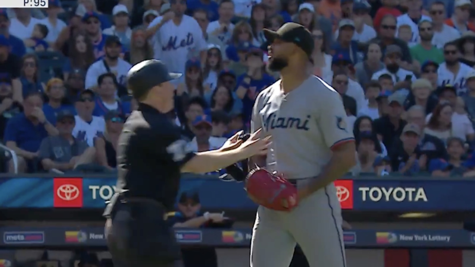 Sandy Alcantara is held back by an umpire