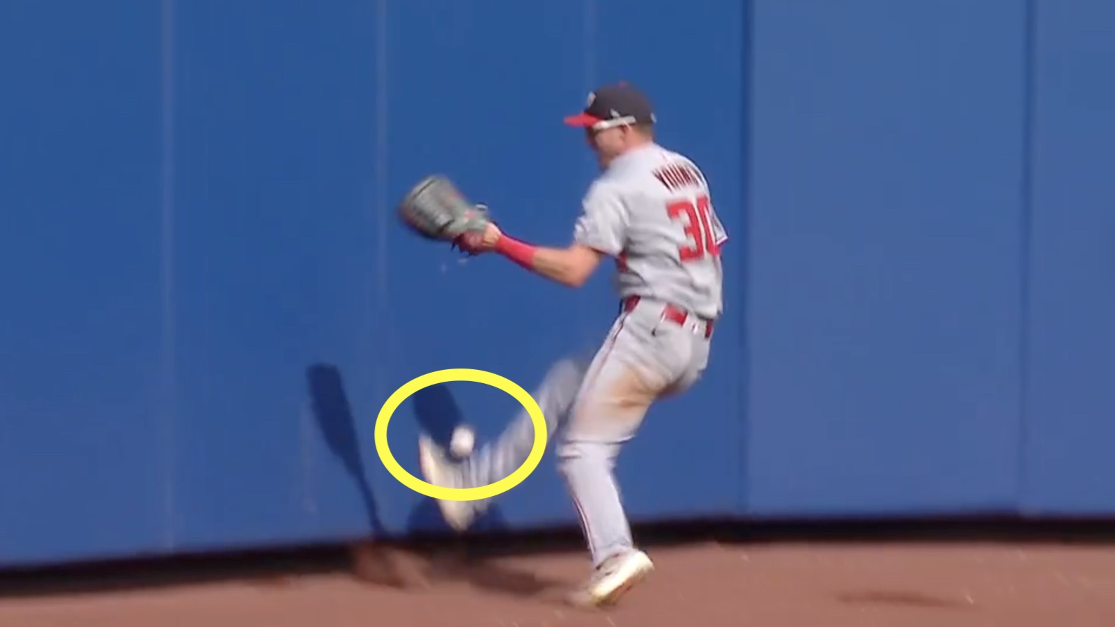 Nationals outfielder Jacob Young kicking the baseball for a catch