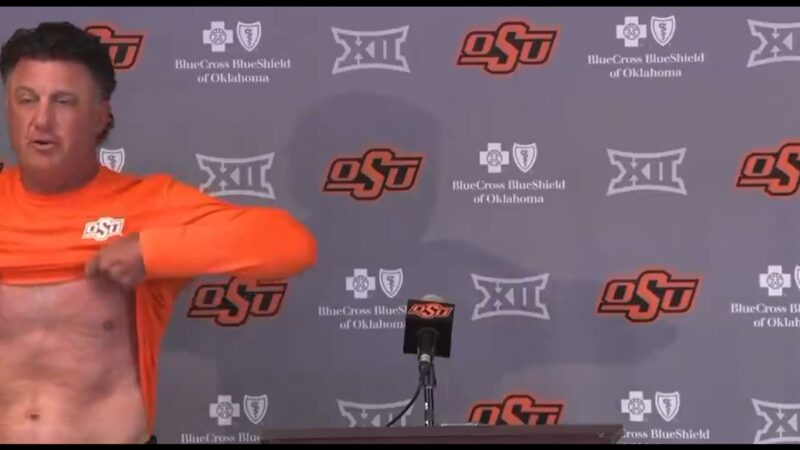 Mike Gundy holding up his shirt