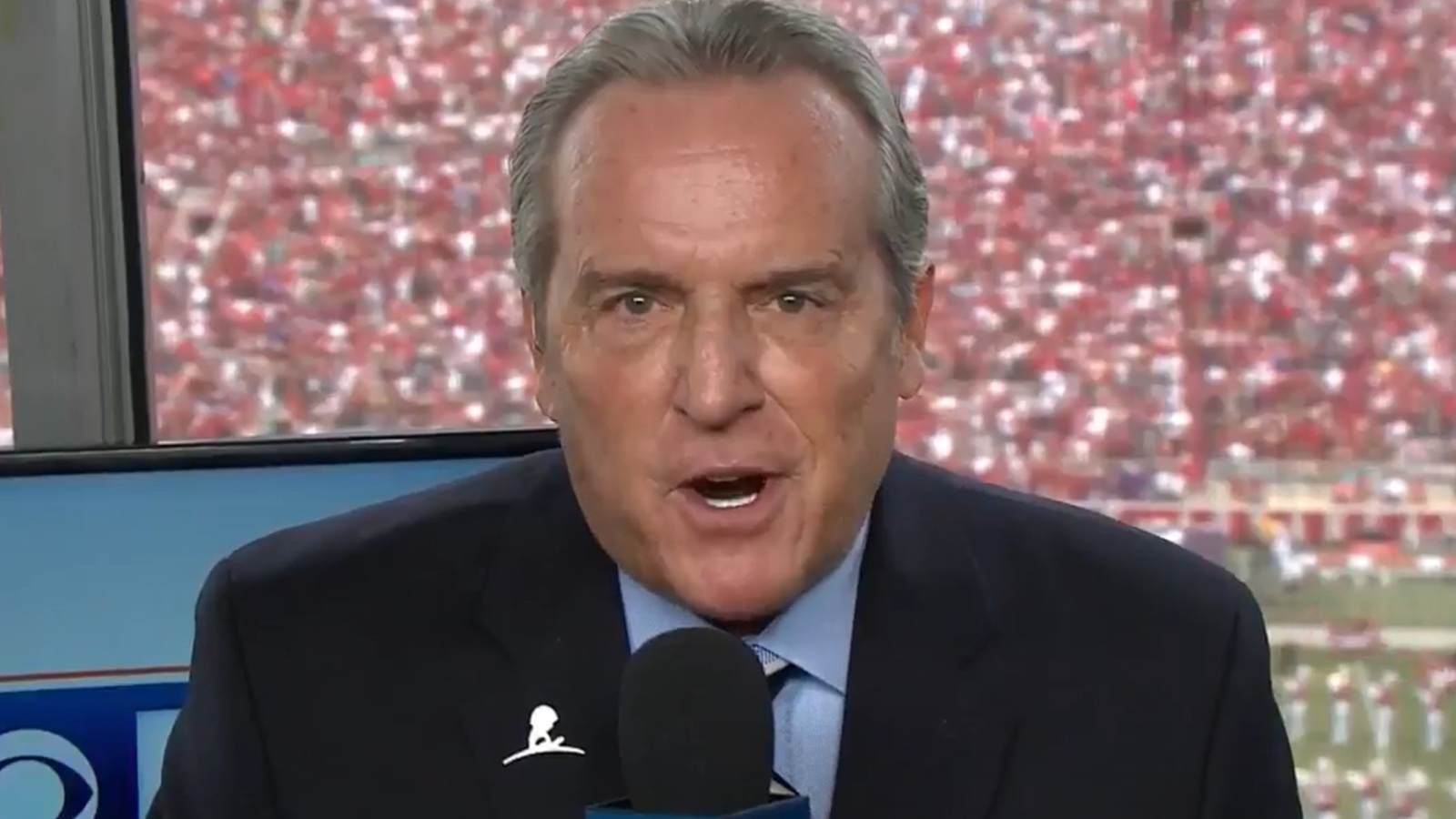 Brad Nessler holding a microphone