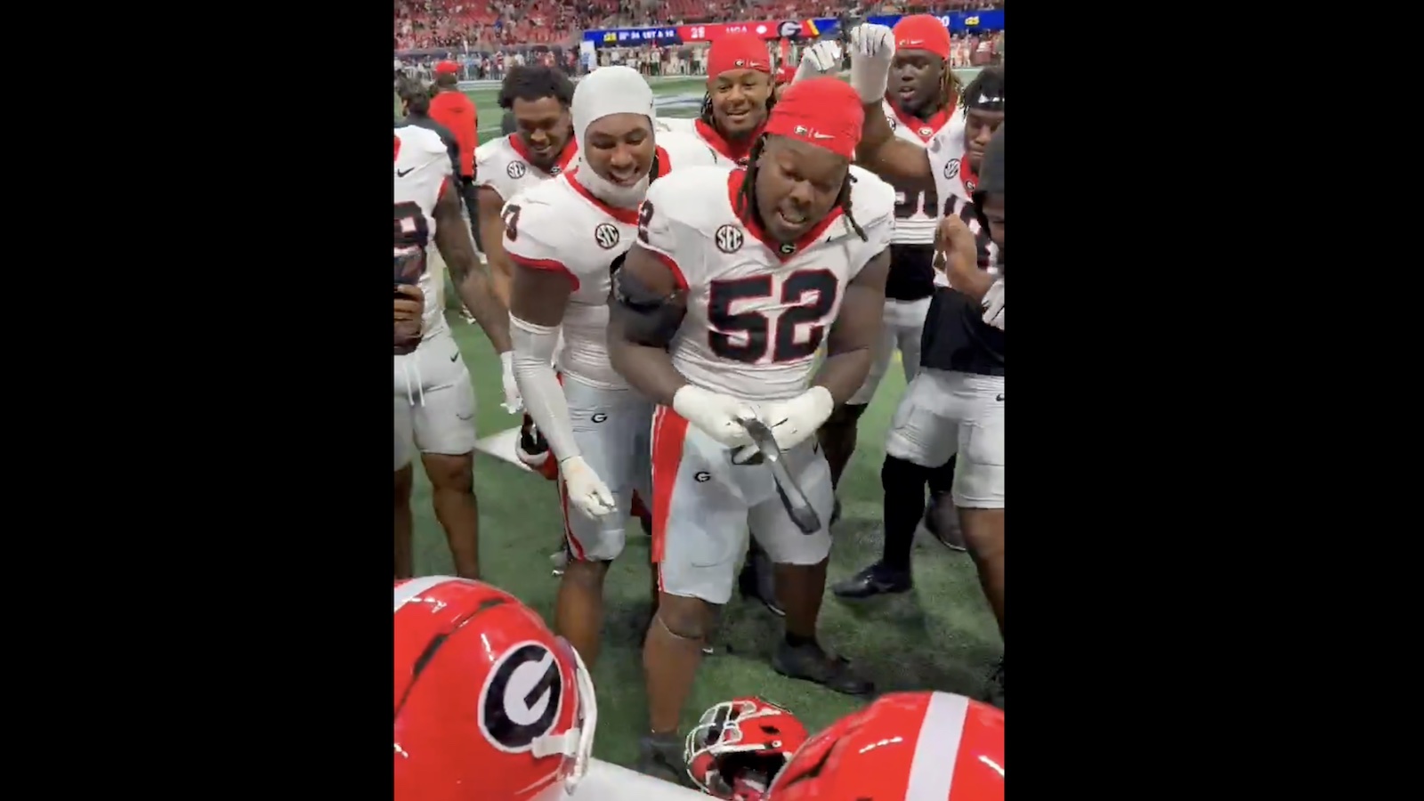 Georgia players gathered around Christen Miller holding a belt