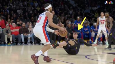 Lakers wing Jake LaRavia on the floor after getting crossed up by Pistons star Cade Cunningham