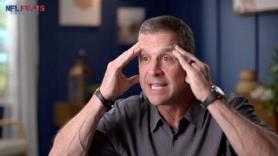 John Harbuagh looking embarrassed after getting stumped by a question about his brother, Jim Harbaugh.