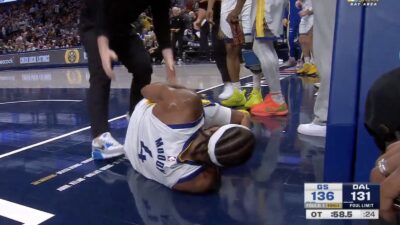 Warriors wing Moses Moody grabbing his left knee after suffering an injury