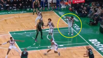 Joel Embiid holding onto his knee in pain