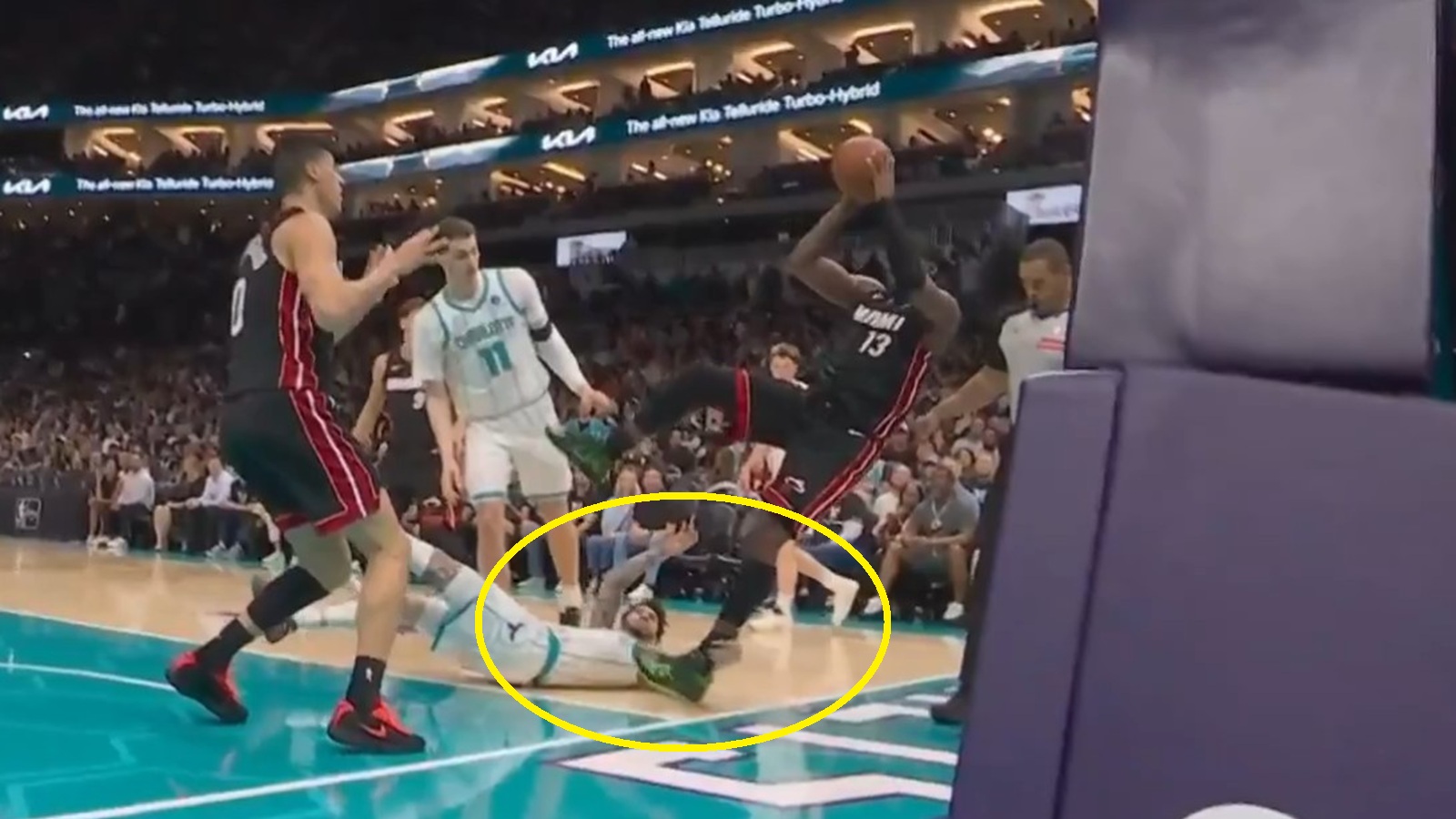 LaMelo Ball grabbing Bam Adebayo's leg