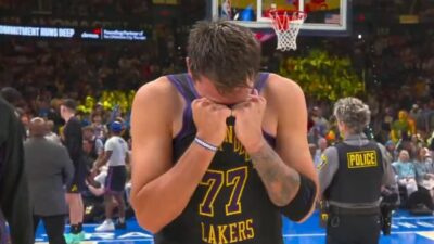 Luka Doncic with his head buried in his jersey