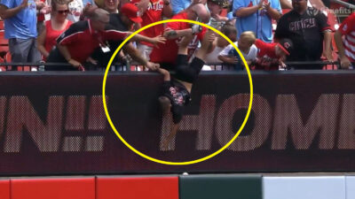 A fan trying to reach a baseball during an MLB game