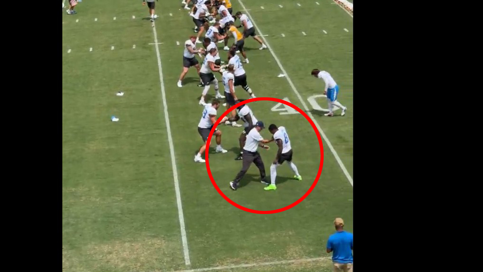 Jim Harbaugh on the field with Chargers players