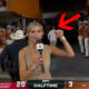 Laura Rutledge holding a mic as Steve Sarkisian runs in the background