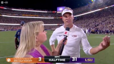 LSU coach Lane Kiffin being interviewed during game against Michigan
