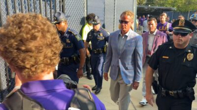 Lane Kiffin flanked by police