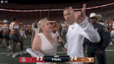 Texas coach Steve Sarkisian flashing the Hook 'em Horns sign while Holly Rowe tried to interview him