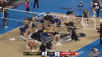 Volleyball players wipe the court during event at Wrigley Field