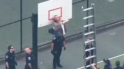 Guy pants stuck basketball hoop