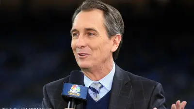 Cris Collinsworth holds a microphone
