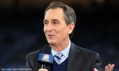 Cris Collinsworth holds a microphone