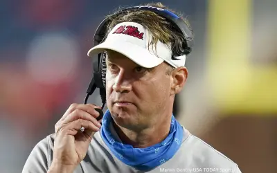 Lane Kiffin holds his headset