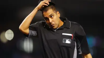 Umpire Gabe Morales holds his hat