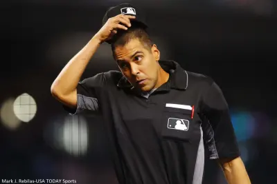 Umpire Gabe Morales holds his hat
