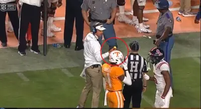 Lane Kiffin holds up a golf ball