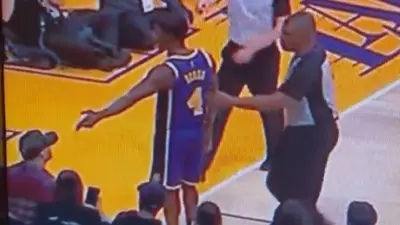 Rajon Rondo points at a fan sitting courtside