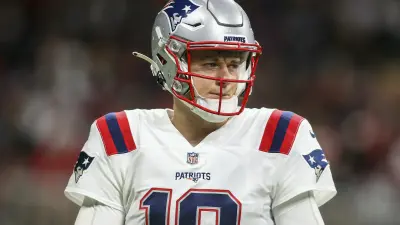 Mac Jones looks on during a game