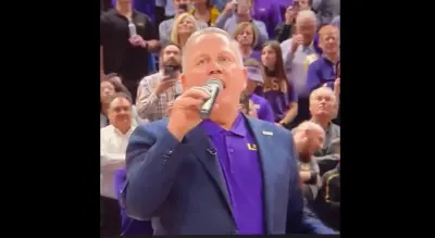 Brian Kelly holds a microphone
