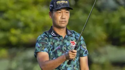 Kevin Na holds a club
