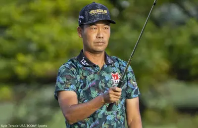 Kevin Na holds a club