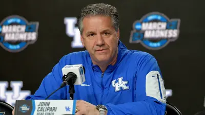 John Calipari in a Kentucky jacket at the podium