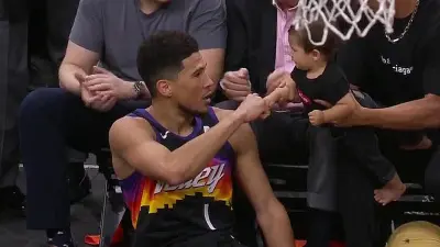 Devin Booker gives a baby a fist bump
