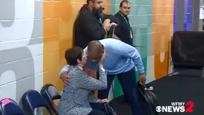 Hubert Davis hugs Mickie Krzyzewski
