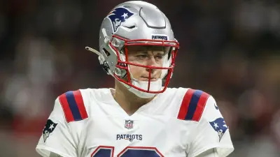 Mac Jones looks on in a Patriots uniform