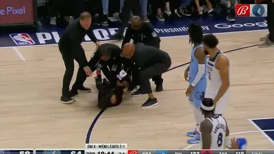 A woman on the ground surrounded by security
