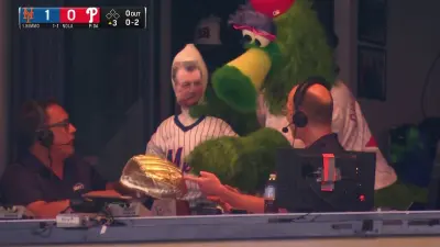 The Phillie Phanatic holding a Keith Hernandez blow-up doll.