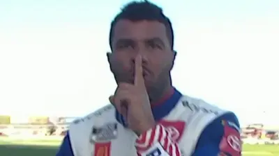 Bubba Wallace holds his finger over his mouth