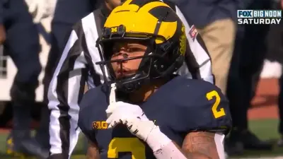 Blake Corum holds his mouthguard