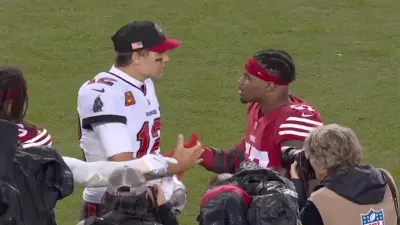 Tom Brady and Dre Greenlaw shake hands