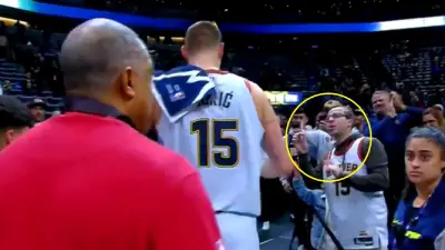 Nikola Jokic walking by a fan