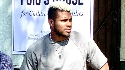 Yasiel Puig in front of a sign