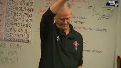 Brian Dutcher standing in front of a board