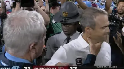 Mack Brown holding Shane Beamer's throat