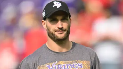Kirk Cousins wearing a Vikings cap and shirt