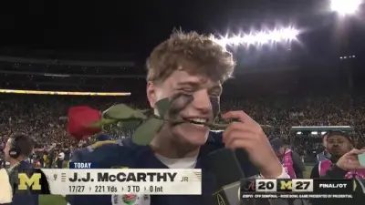 Michigan quarterback JJ McCarthy with a rose in his mouth after winning the Rose Bowl against Alabama.