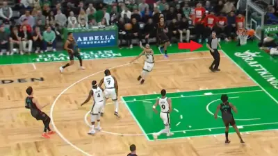 Deni Avdija lobs a pass to referee Mark Lindsay during a Celtics-Wizards game
