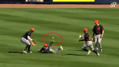 Andrew Navigato kicks the live baseball during Rays-Tigers spring training game