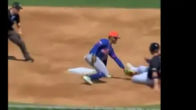 A player is tagged while sliding into second base