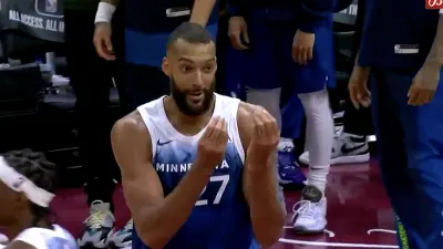 Timberwolves center doing the "money" gesture at NBA referee Scott Foster