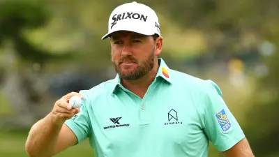 Graeme McDowell picks up his ball